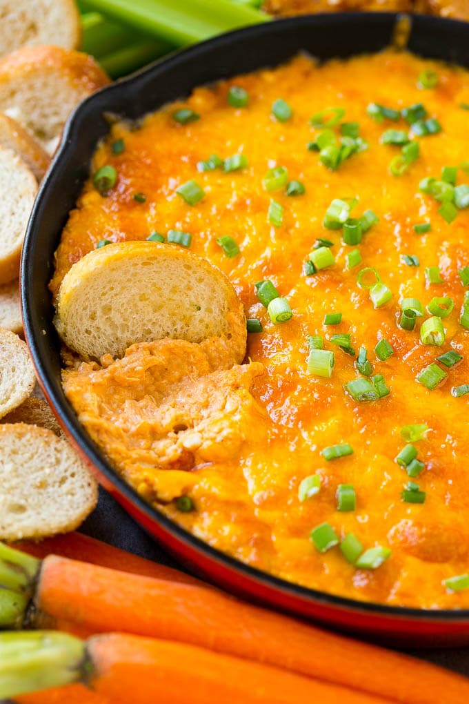 Buffalo Ranch Chicken Dip | Buffalo Chicken Dip | Baked Buffalo Dip | Cheesy Buffalo Dip #buffalowings #buffalochicken #dip #lowcarb #appetizer #fuyos Buffalo ranch chicken dip with a baguette slice in it.