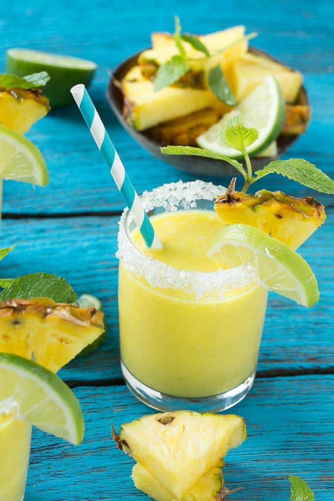 Pineapple Coconut Smoothie Recipe |Tropical Smoothie | Pineapple Smoothie #smoothie #pineapple #coconut #healthy #cleaneating #fuyos A tropical smoothie with a paper straw in it.