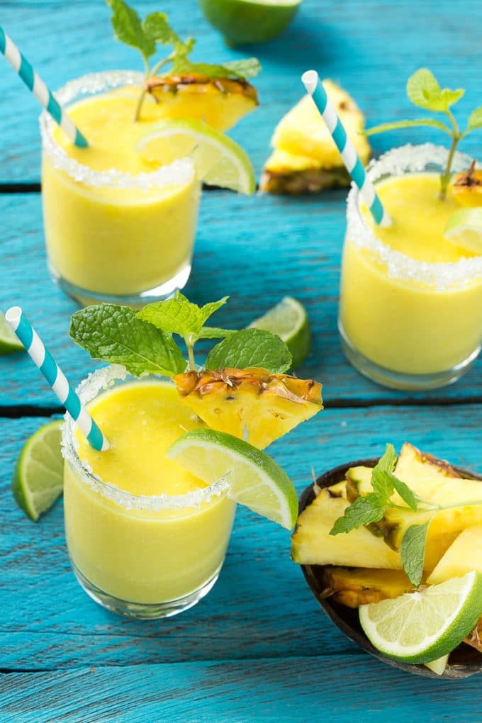 Pineapple Coconut Smoothie Recipe |Tropical Smoothie | Pineapple Smoothie #smoothie #pineapple #coconut #healthy #cleaneating #fuyos Pineapple coconut smoothies in glasses with sugared rims.