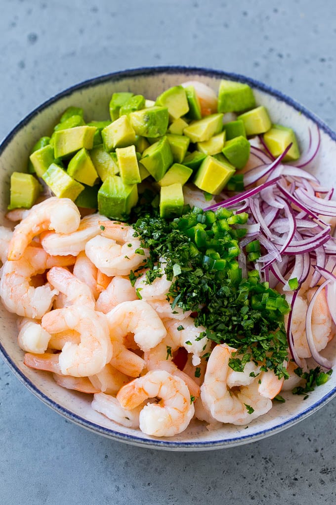 Mexican Shrimp Cocktail Recipe | Coctel de Camarones | Shrimp Cocktail | Mexican Shrimp #shrimp #appetizer #avocado #mexican #fuyos Shrimp, red onion, avocado, jalapeno and cilantro in a serving bowl.