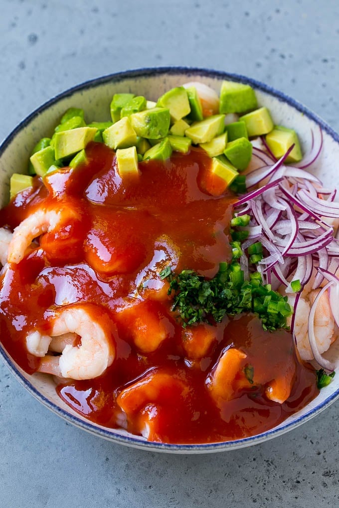 Mexican Shrimp Cocktail Recipe | Coctel de Camarones | Shrimp Cocktail | Mexican Shrimp #shrimp #appetizer #avocado #mexican #fuyos Shrimp, avocado, red onion and cilantro topped with cocktail sauce.
