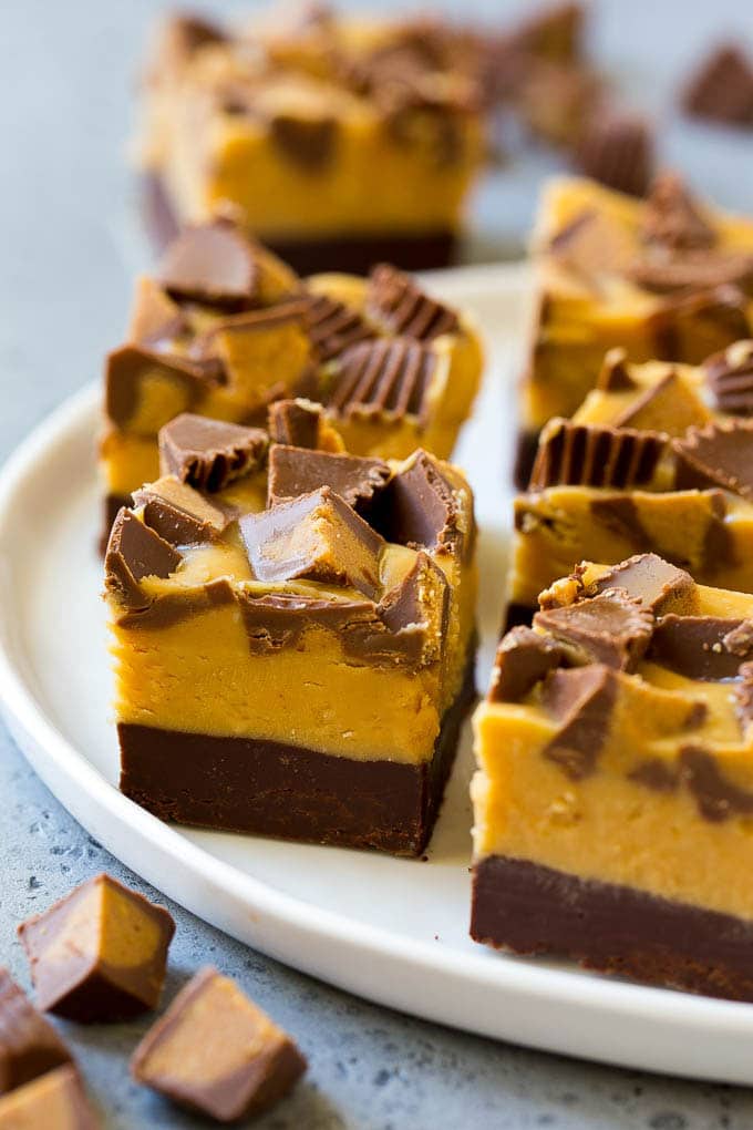 Chocolate Peanut Butter Fudge Recipe | Peanut Butter Cup Fudge | Easy Fudge Recipe #chocolate #peanutbutter #fudge #baking #dessert #fuyos Squares of chocolate peanut butter fudge topped with peanut butter cups.