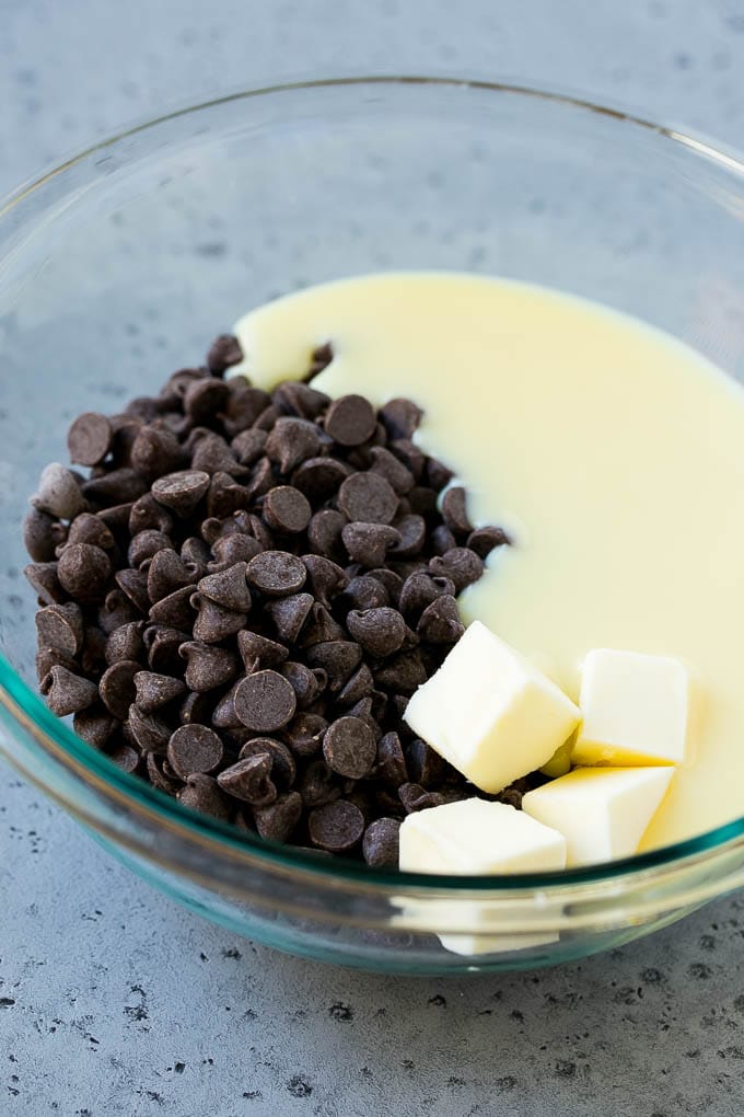 Chocolate Peanut Butter Fudge Recipe | Peanut Butter Cup Fudge | Easy Fudge Recipe #chocolate #peanutbutter #fudge #baking #dessert #fuyos Chocolate chips, condensed milk and butter in a mixing bowl.