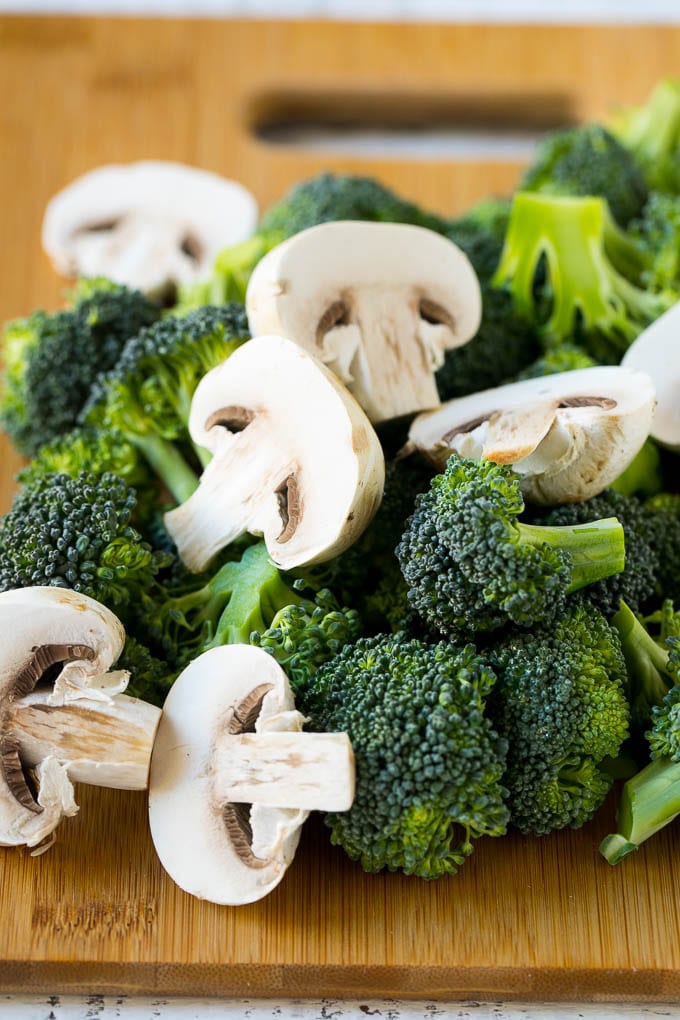 Chicken and Broccoli Stir Fry Recipe | Chicken Stir Fry | Healthy Chicken Recipe | Chicken and Broccoli | Chinese Food #chicken #broccoli #stirfry #healthy #cleaneating #dinner #fuyos Broccoli florets and sliced mushrooms on a cutting board.