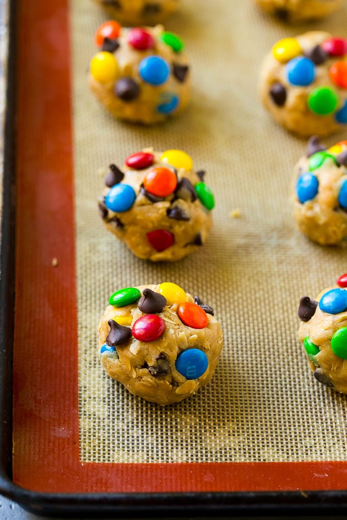 Monster Cookies Recipe | Oatmeal Cookies | Peanut Butter Cookies | M&M's Cookies #baking #cookies #dessert #peanutbutter #chocolate #fuyos Balls of cookie dough on a baking sheet.