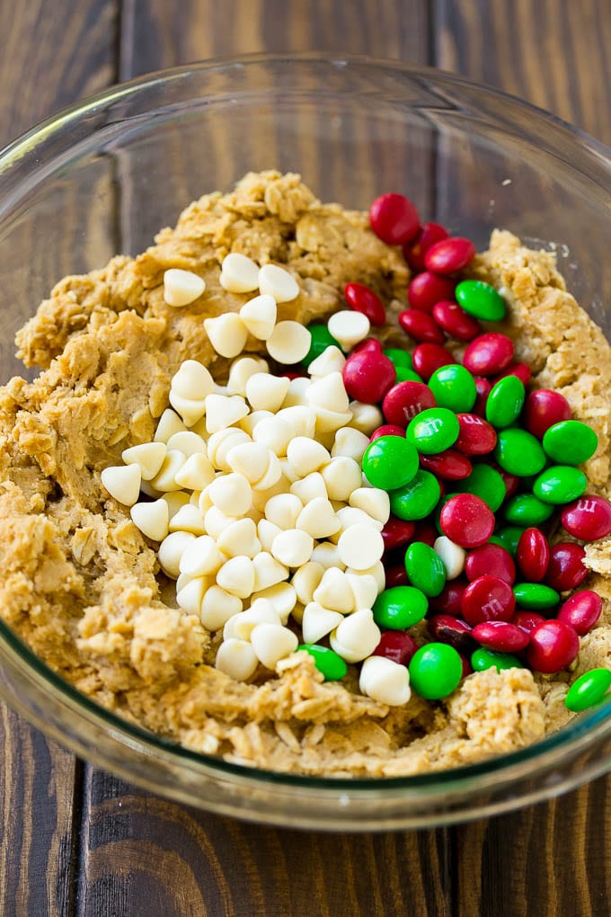 Christmas Monster Cookies Recipe | Oatmeal Cookies | Peanut Butter Cookies | M&M's Cookies #baking #cookies #dessert #peanutbutter #chocolate #fuyos #christmas #sprinkles Cookie dough with red and green M&M's and white chocolate chips.