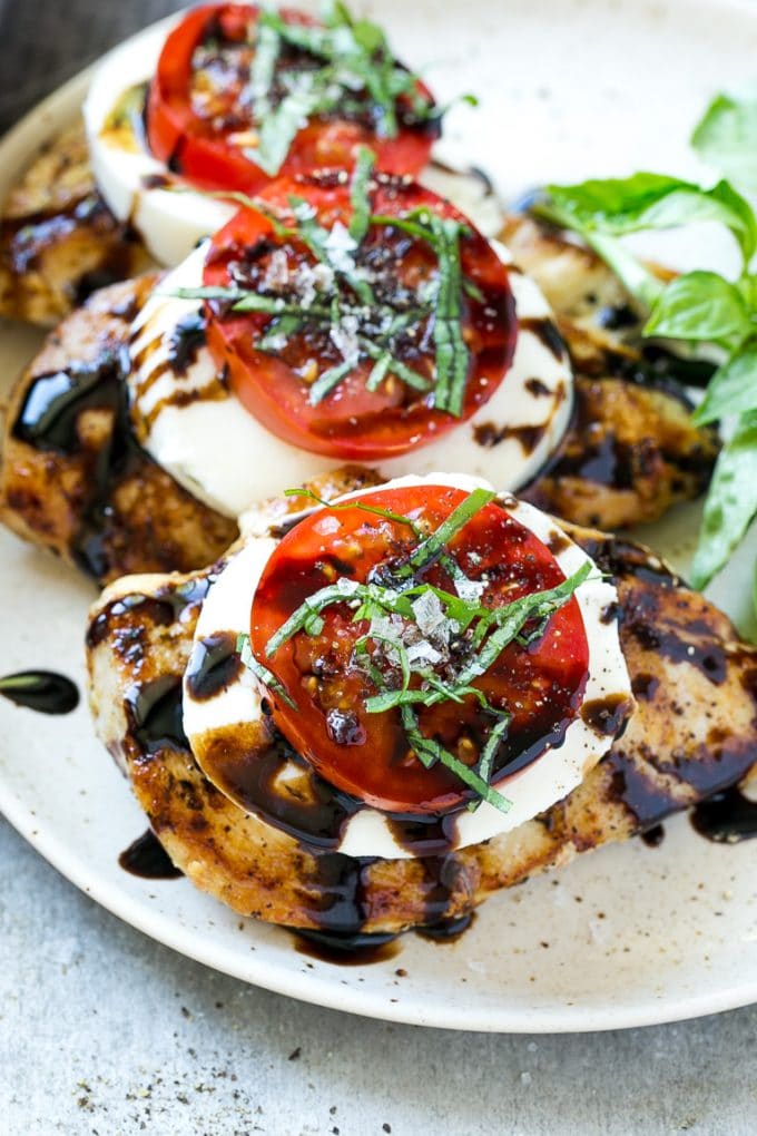 Chicken caprese with sliced tomatoes, balsamic glaze, fresh mozzarella and shredded basil.