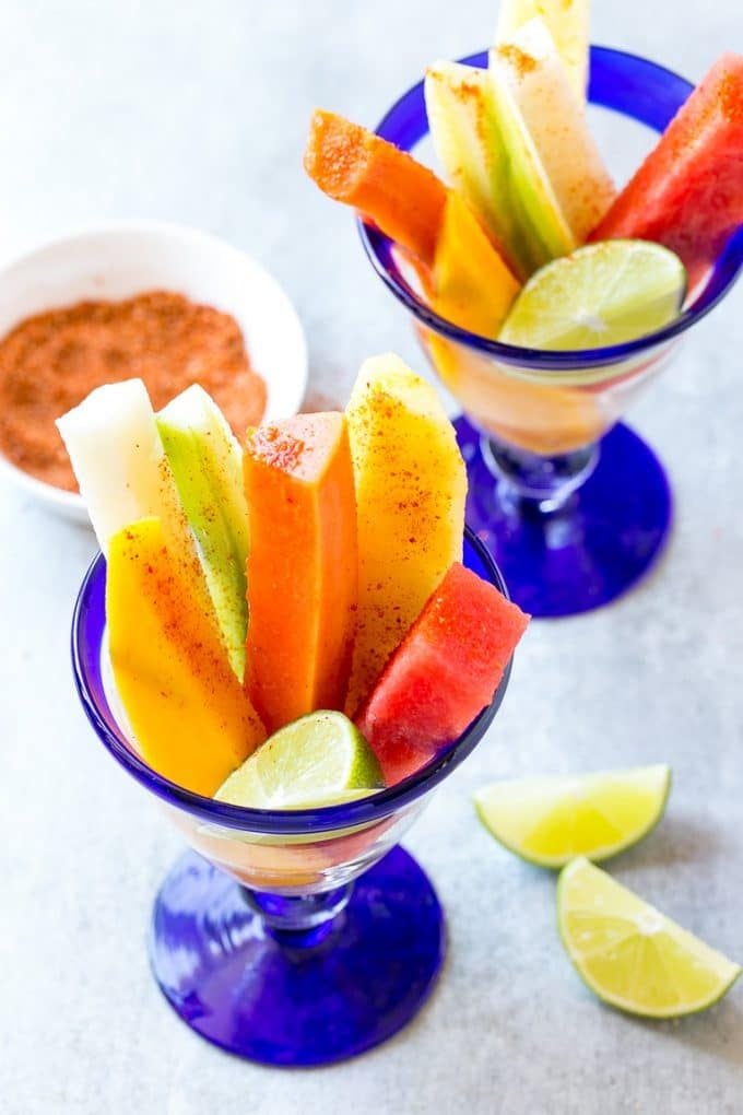 Mexican Fruit Cups | Fruit Cups | Mexican Fruit | Tropical Fruit #fruit #fruitcup #watermelon #pineapple #snack #healthy #fuyos Spears of watermelon, cucumber, jicama, mango and pineapple in glasses.
