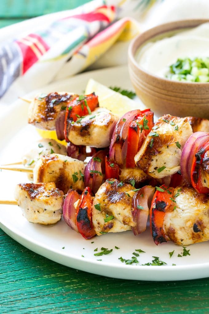 Greek Chicken Kabobs | Grilled Chicken Kabobs | Healthy Chicken Recipe | Greek Chicken #greekfood #chicken #grilling #grilledchicken #kabobs #dinner #fuyos A stack of Greek chicken skewers made with peppers and onions.