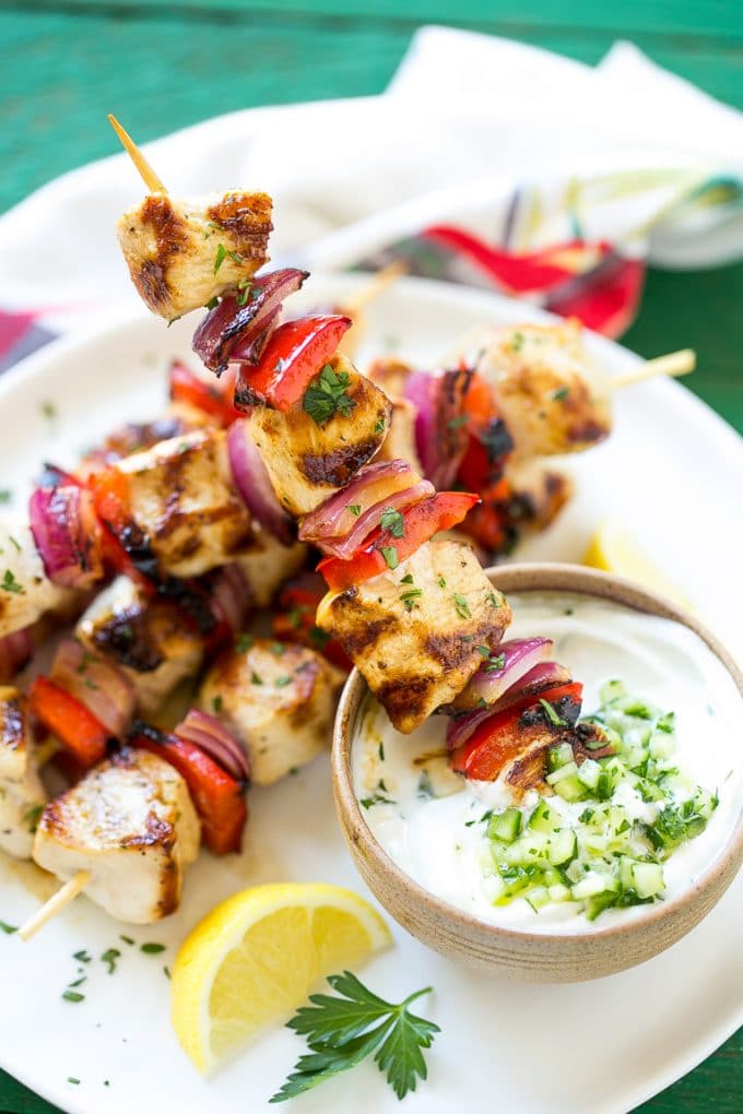 Greek Chicken Kabobs | Grilled Chicken Kabobs | Healthy Chicken Recipe | Greek Chicken #greekfood #chicken #grilling #grilledchicken #kabobs #dinner #fuyos Skewered meat and veggies being dipped onto cucumber yogurt sauce.