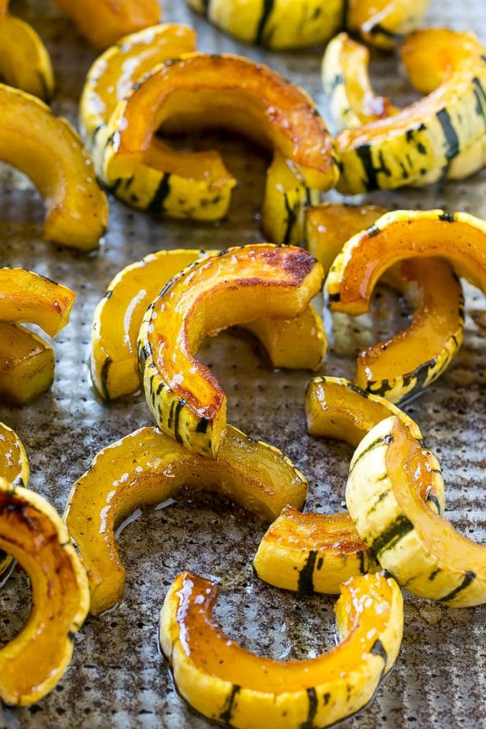 Brown Sugar Delicata Squash Recipe | Roasted Squash | Delicata Squash | Winter Squash Recipe #squash #wintersquash #brownsugar #sidedish #delicatasquash #dinner #fuyos Roasted delicata squash on a sheet pan seasoned with brown sugar.