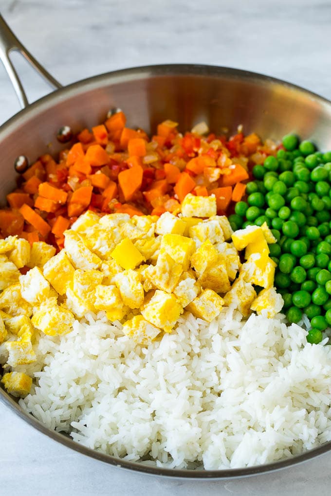 Veggie Fried Rice Recipe | Vegetarian Fried Rice #rice #friedrice #vegetarian #dinner #fuyos #sidedish Vegetables, scrambled egg, rice and peas in a frying pan.