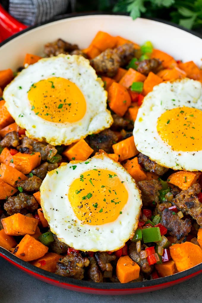 Sweet Potato Hash #sweetpotato #sausage #breakfast #brunch #fuyos A pan of sweet potato hash topped with fried eggs.