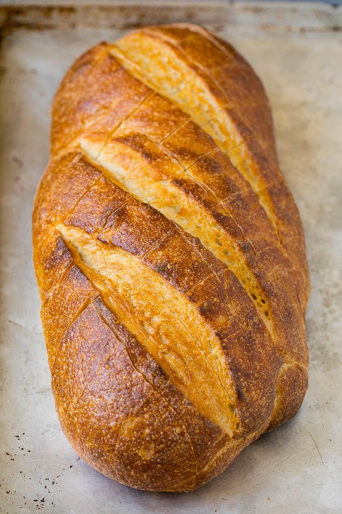 Pull Apart Bread | Garlic Bread | Cheese Bread #bread #garlic #cheese #sidedish #appetizer #fuyos A loaf of bread on a sheet pan with diagonal cuts in it.