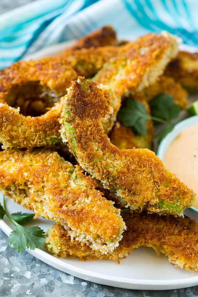 Avocado Fries Recipe | Fried Avocado | Avocado Fritters #avocado #appetizer #snack #fuyos A plate of avocado fries garnished with fresh cilantro.