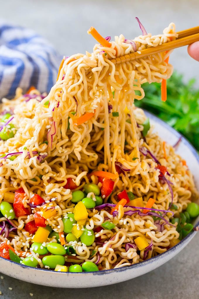 Asian Noodle Salad Recipe | Ramen Noodle Salad | Asian Salad #salad #noodles #edamame #vegetarian #fuyos #lunch Chopsticks picking up noodles in a vegetable salad.