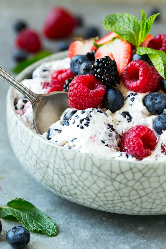 Berry Cheesecake Salad Recipe | Fruit Salad | Berry Fruit Salad | Cheesecake Salad #salad #cheesecake #fruit #berries #sidedish #dessert #fuyos Berry cheesecake salad in a bowl garnished with fresh berries and mint.