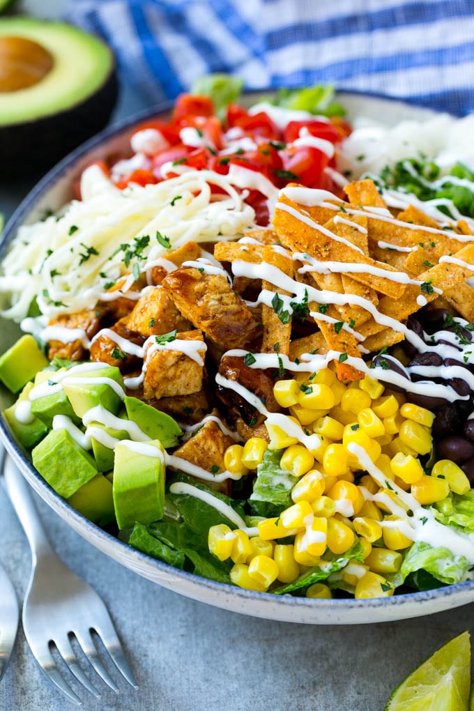 BBQ Chicken Salad Recipe | Chopped BBQ Chicken Salad | CPK Copycat Recipe | California Pizza Kitchen Copycat Recipe | Chicken Ranch Salad #copycat #CPK #BBQchicken #chicken #salad #dinner #fuyos A bowl of BBQ chicken salad topped with a drizzle of ranch dressing.