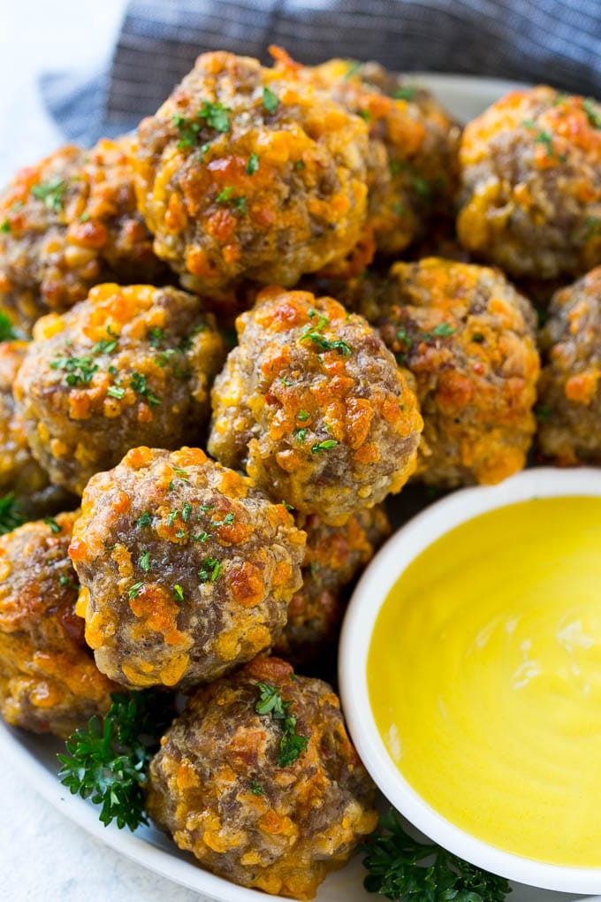 Sausage Cheese Balls Recipe | Sausage Balls Recipe | Bisquick Sausage Balls #sausage #sausageballs #balls #appetizer #cheeseballs #fuyos A platter of sausage cheese balls with honey mustard sauce for dipping.