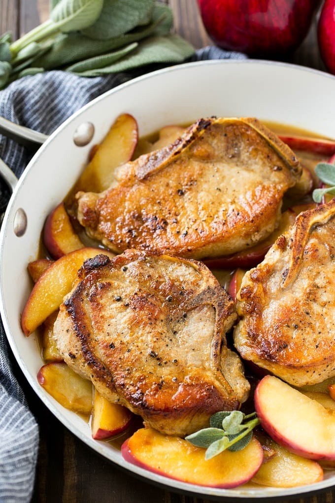 Apple Pork Chops Recipe | Pork Chops with Apples | Cider Pork Chops | Bone In Pork Chops Recipe #pork #porkchops #fall #apple #dinner #fuyos A pan of apple pork chops garnished with fresh sage.