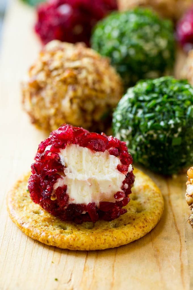 Cheese Ball Bites Recipe | Holiday Cheese Ball Recipe | Pecan Cheese Ball | Cranberry Cheese Ball | Mini Cheese Balls #cheeseball #cheese #appetizer #fuyos A cranberry crusted ball of cheese on a cracker.