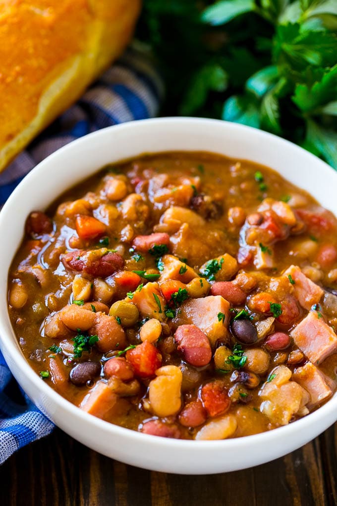 Slow Cooker Ham Bone Soup | Ham and Bean Soup | Ham Bone and Bean Soup | Ham Soup | Leftover Ham Recipe #ham #hamsoup #leftoverham #soup #slowcooker #crockpot #fuyos Crock pot ham bone soup in a bowl topped with parsley.