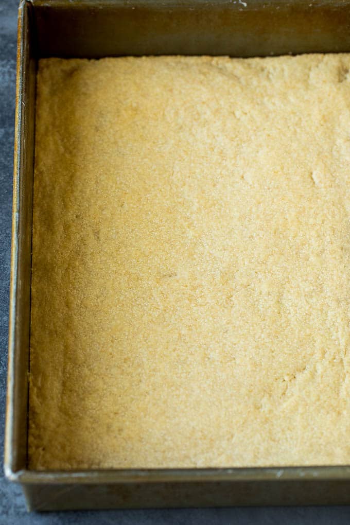 Pecan Pie Bars Recipe #pecans #pie #fall #pecanpie #dessert #thanksgiving #fuyos A shortbread crust in a baking pan.