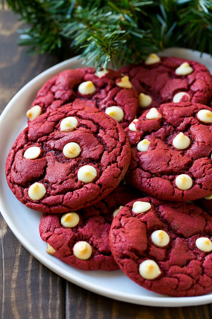 Red Velvet Cookies Recipe | Red Velvet Cookies with White Chocolate Chips | Red Velvet Cake Mix Cookies #redvelvet #cookies #whitechocolate #christmas #fuyos Red Velvet Cookies on a serving plate with holiday decorations nearby,