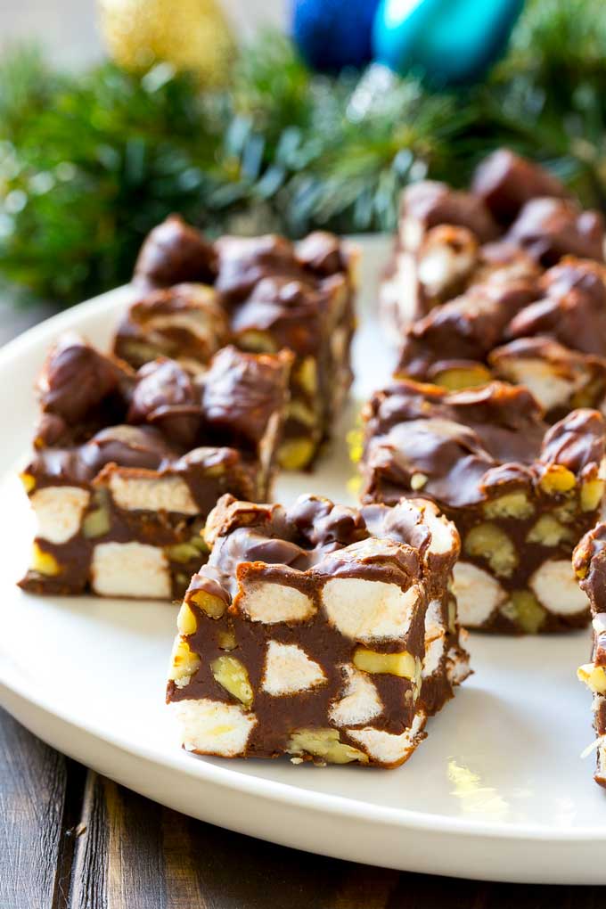 Rocky Road Fudge | Chocolate Marshmallow Fudge | Chocolate Nut Fudge | Microwave Fudge #fudge #chocolatefudge #nobake #chocolate #dessert #rockyroad #fuyos Squares of rocky road fudge on a serving plate.