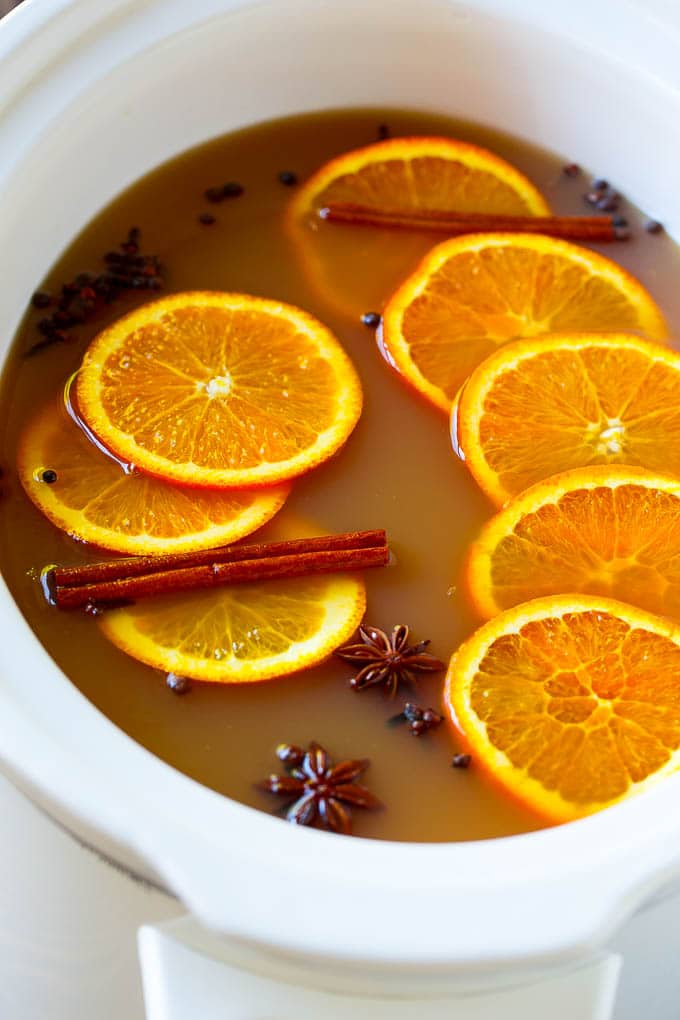 Slow Cooker Apple Cider | Mulled Apple Cider | Crockpot Apple Cider #cider #apple #applecider #drink #crockpot #slowcooker #fuyos Crock pot spiced drink with orange slices and aromatic spices.