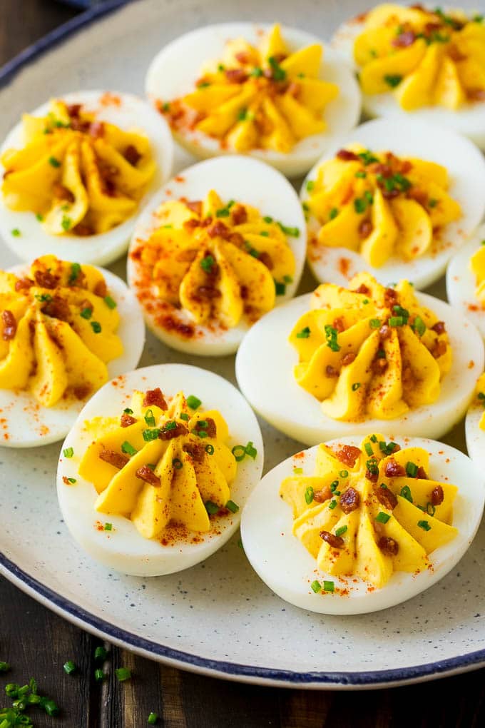 Bacon Deviled Eggs | Deviled Eggs Recipe #eggs #keto #lowcarb #bacon #appetizer #fuyos A plate of bacon deviled eggs garnished with sliced chives and smoked paprika.