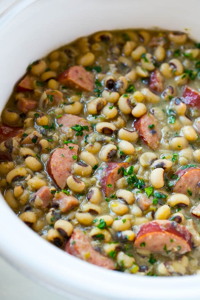 Slow Cooker Black Eyed Peas Recipe | Crock Pot Black Eyed Peas | Southern Black Eyed Peas | Black Eyed Peas with Ham | Black Eyed Peas with Sausage #blackeyedpeas #slowcooker #crockpot #sausage #newyears #dinner #fuyos These crock pot black eyed peas with sausage and ham are the perfect meal for new years.