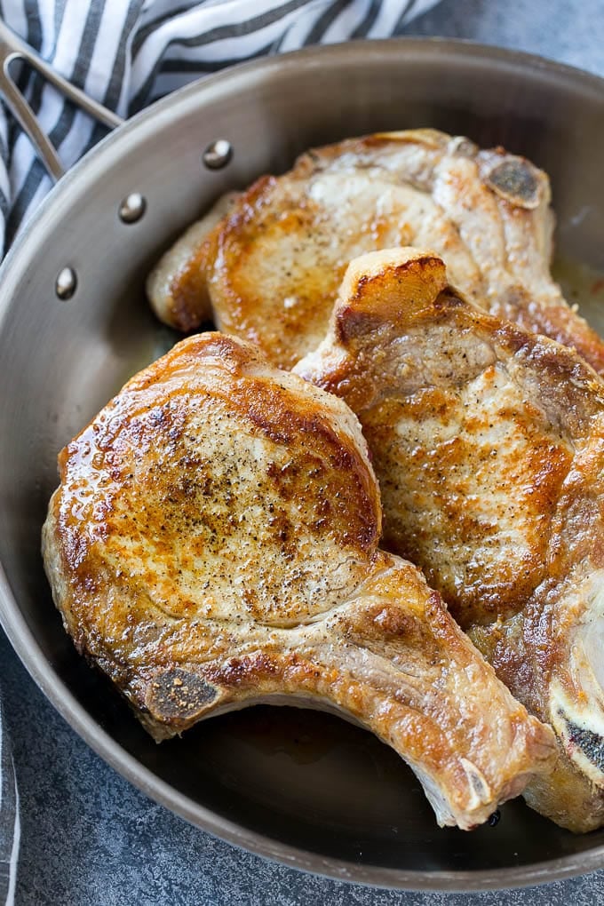 Brown Sugar Pork Chops Recipe | Bone In Pork Chops Recipe | Garlic Butter Pork Chops | Skillet Pork Chops #pork #porkchops #garlic #dinner #glutenfree #fuyos Browned bone in pork chops in a frying pan.