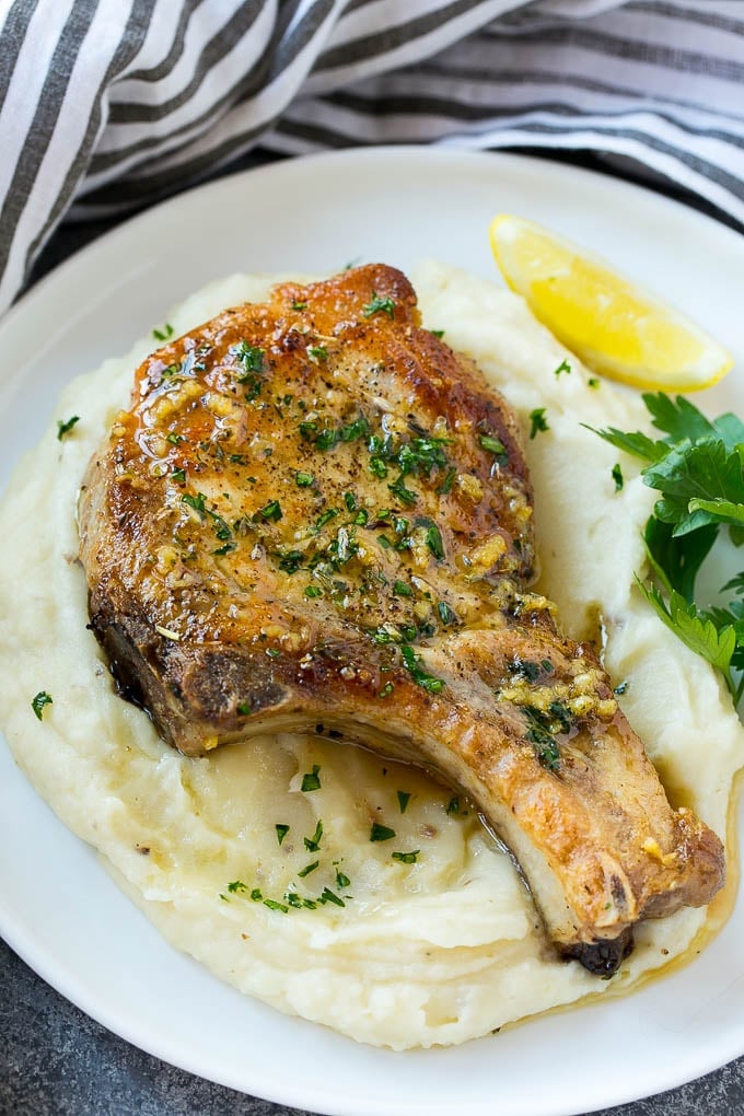 Brown Sugar Pork Chops Recipe | Bone In Pork Chops Recipe | Garlic Butter Pork Chops | Skillet Pork Chops #pork #porkchops #garlic #dinner #glutenfree #fuyos Brown sugar pork chops on a bed of mashed potatoes.