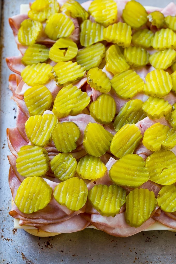 Cuban Sliders Recipe | Cuban Sandwich Recipe | Slider Sandwiches | Ham and Cheese Sliders #sliders #sandwiches #ham #cheese #appetizer #fuyos Bread layered with cheese, ham and pickles.