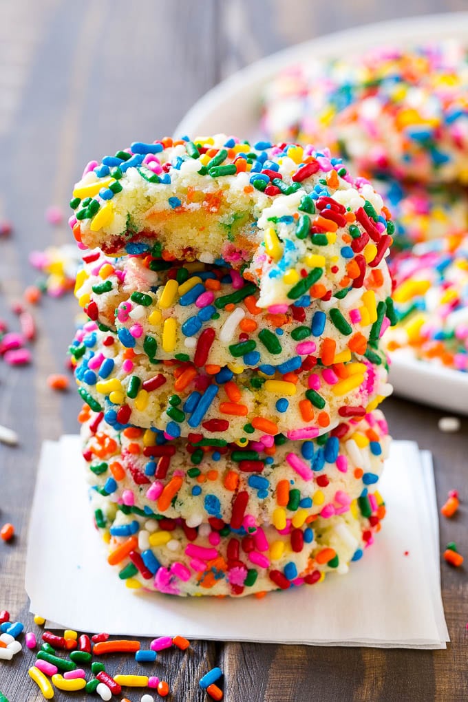Funfetti Cookies Recipe | Funfetti Cake Mix Cookies | Sprinkle Cookies | Cake Mix Cookies #cookies #funfetti #sprinkles #dessert #fuyos A stack of funfetti cookies with a bite taken out of one.