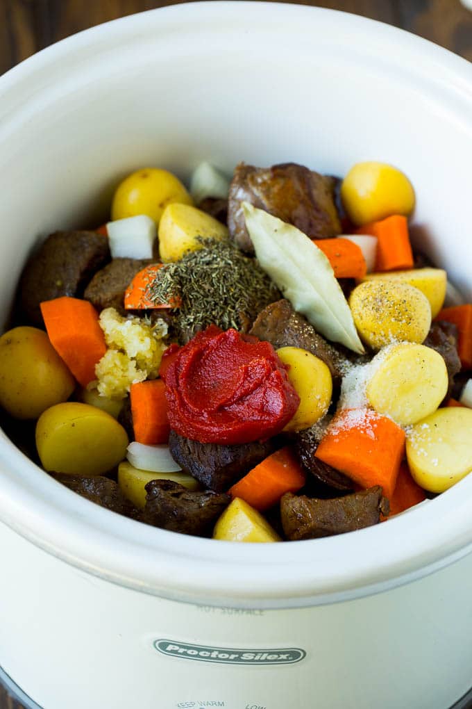 Slow Cooker Beef Stew Recipe | Crockpot Beef Stew #stew #soup #beef #slowcooker #crockpot #dinner #fuyos A crock pot filled with beef, vegetables, tomato paste, herbs and spices.