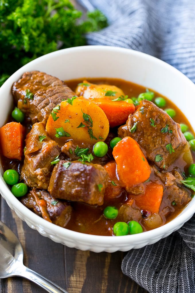 Slow Cooker Beef Stew Recipe | Beef and Potato Stew | Crock Pot Beef Stew | Easy Beef Stew #beef #beefstew #soup #slowcooker #crockpot #dinner #fuyos A bowl of slow cooker beef stew with meat, carrots, potatoes and peas.