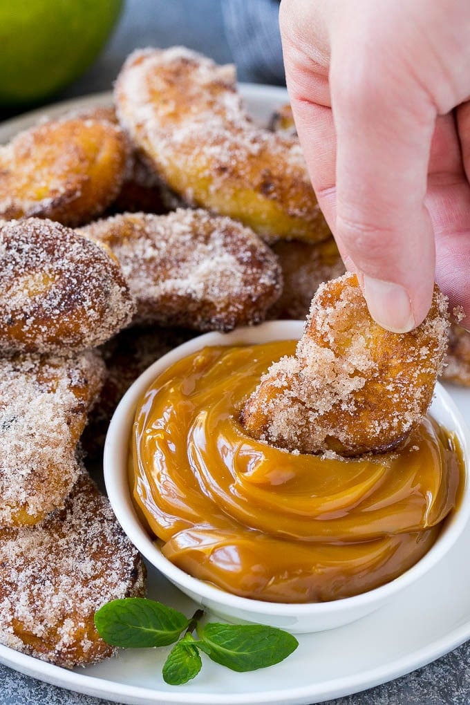 Apple Fries Recipe | Fried Apples Recipe | Cinnamon Sugar Apples | Apple Dessert Recipe #apples #dessert #fuyos #fall An apple fry being dipped into caramel sauce.