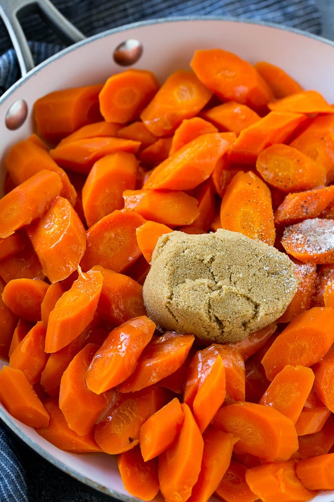 Candied Carrots Recipe | Carrot Side Dish | Brown Sugar Carrots | Glazed Carrots #carrots #brownsugar #sidedish #dinner #fuyos Sliced carrots with butter, brown sugar and seasonings in a pan.
