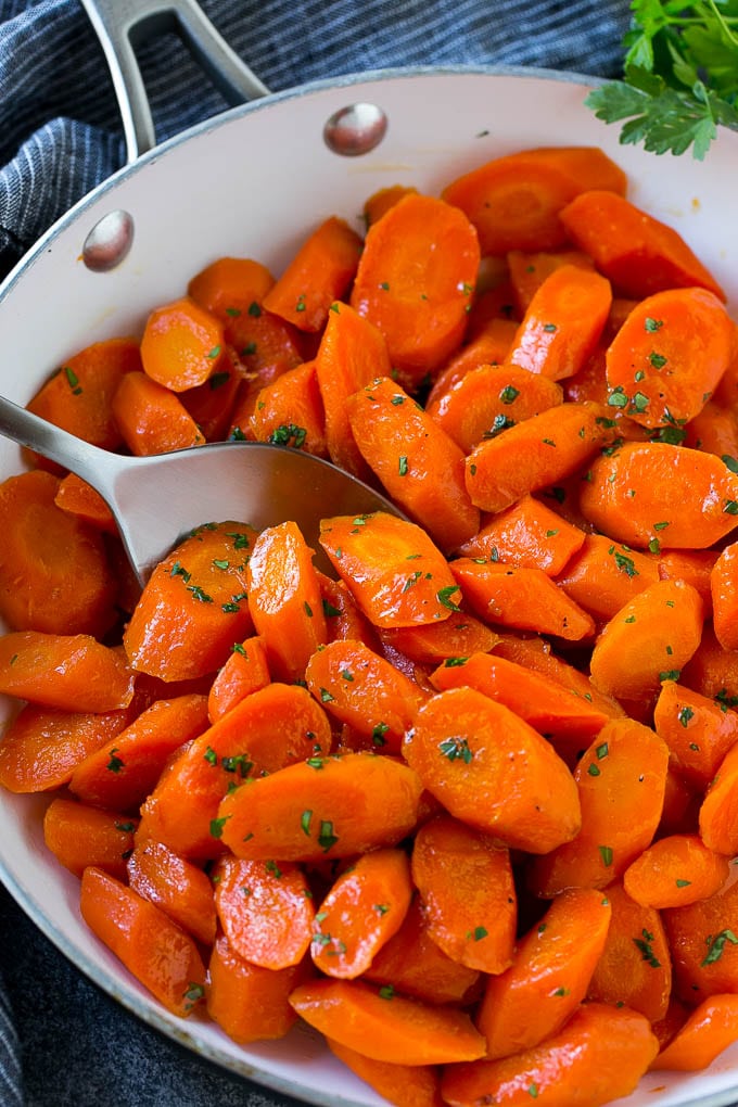 Candied Carrots Recipe | Carrot Side Dish | Brown Sugar Carrots | Glazed Carrots #carrots #brownsugar #sidedish #dinner #fuyos Candied carrots in a pan with a serving spoon.