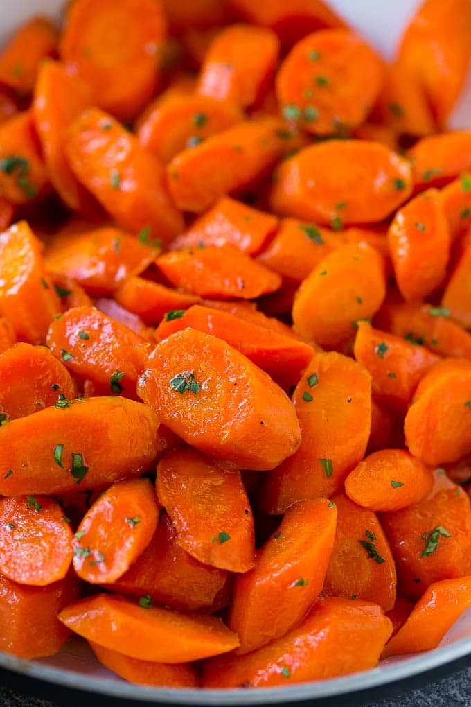 Candied Carrots Recipe | Carrot Side Dish | Brown Sugar Carrots | Glazed Carrots #carrots #brownsugar #sidedish #dinner #fuyos A close up of cooked candied carrots topped with parsley.