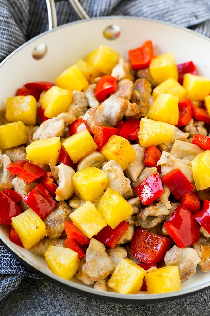 Pineapple Chicken | Hawaiian Chicken | Chicken Stir Fry #pineapple #chicken #dinner #stirfry #fuyos A skillet of cooked chicken, pineapple and red bell peppers.