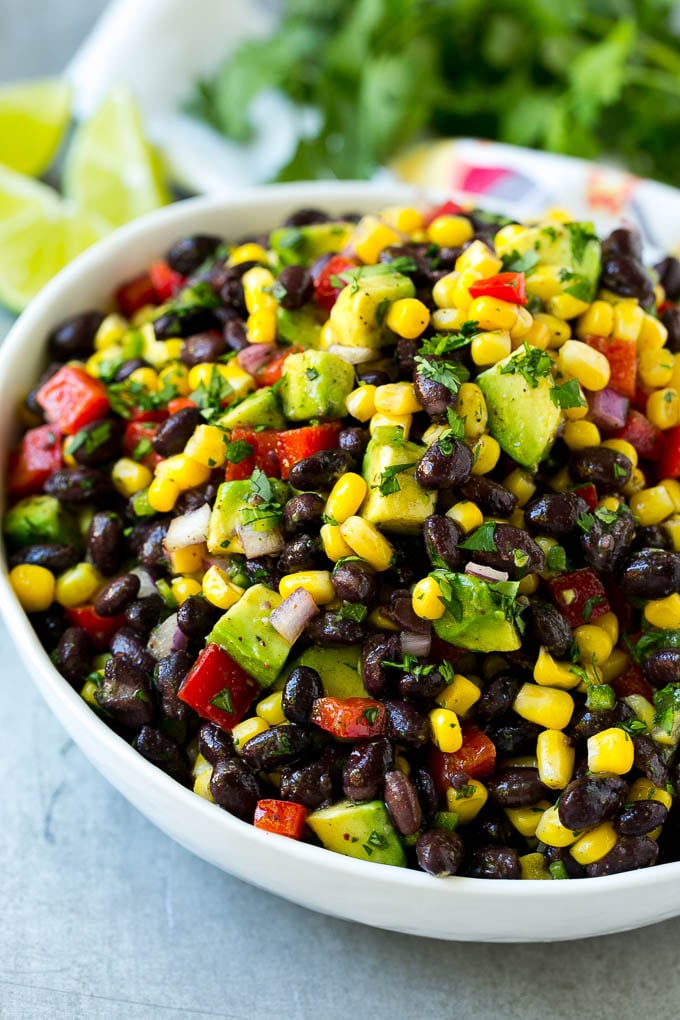 Black Bean and Corn Salad Recipe | Mexican Salad | Black Bean Salad | Bean Salad #salad #beans #corn #mexicanfood #fuyos A bowl of black bean and corn salad loaded with avocado and red pepper, garnished with fresh cilantro.