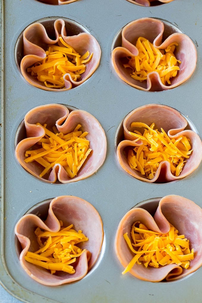 Ham and Egg Cups Recipe | Low Carb Breakfast | Ham and Eggs #ham #eggs #lowcarb #breakfast #fuyos Ham pressed into muffin tins and topped with shredded cheese.