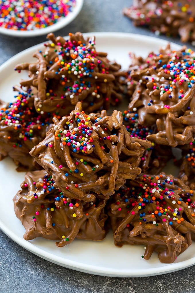 Haystack Cookies Recipe | No Bake Cookies | Chow Mein Noodle Cookies #nobakecookies #cookies #recipe #chocolate #fuyos A plate of haystack cookies topped with rainbow sprinkles.