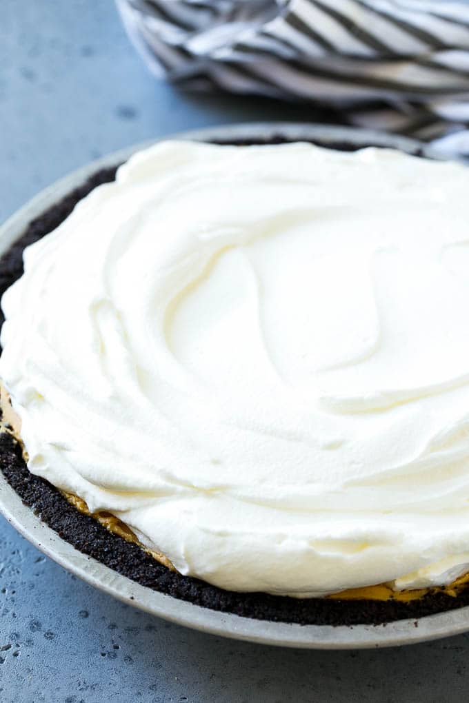 Whipped cream topping on top of a nut butter tart.