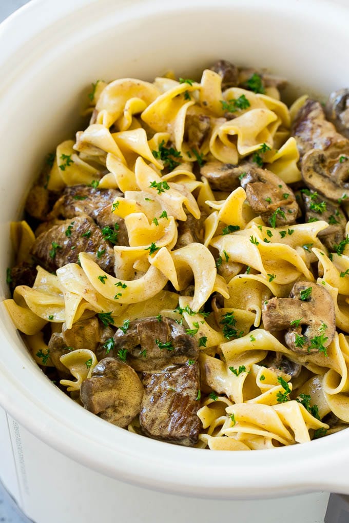 Slow Cooker Beef Stroganoff Recipe | Crock Pot Beef Stroganoff | Beef Recipe #slowcooker #crockpot #beef #mushrooms #pasta #dinner #fuyos Slow cooker beef stroganoff with chunks of beef, mushrooms and egg noodles topped with parsley.