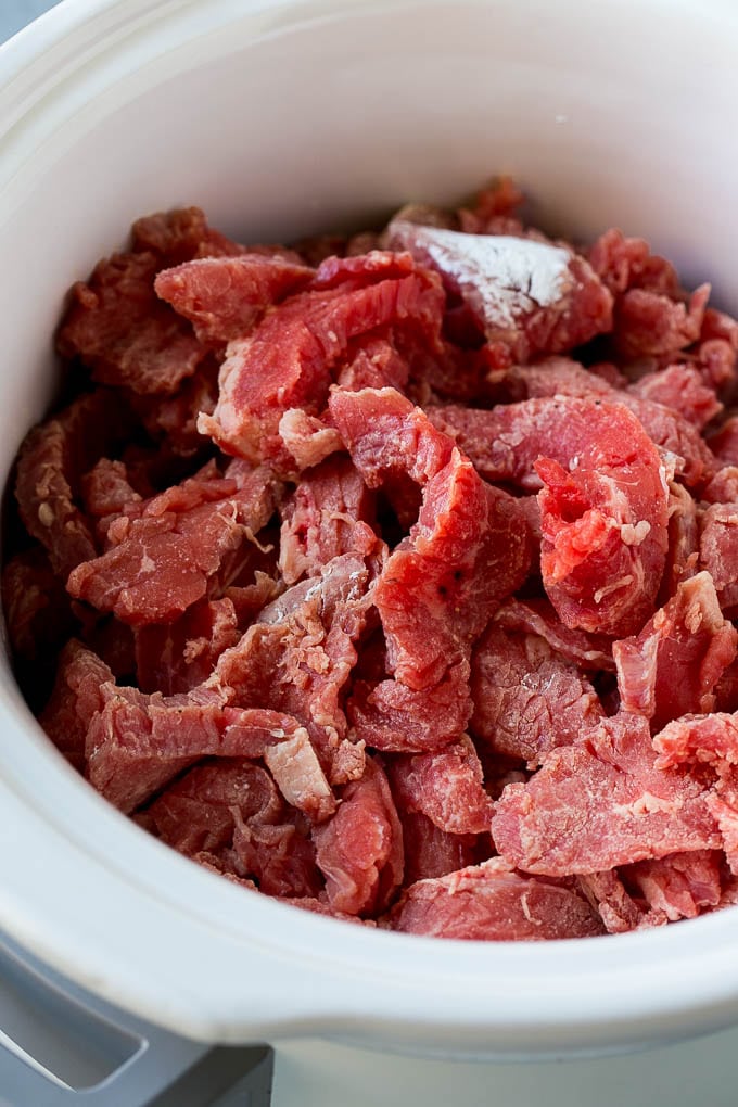Slow Cooker Korean Beef Recipe | Korean Beef | Flank Steak Recipe #dinner #beef #slowcooker #crockpot #asian #fuyos Flank steak strips tossed in cornstarch inside a slow cooker.