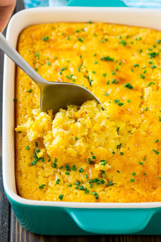 Corn Pudding Recipe | Corn Casserole | Corn Side Dish #corn #pudding #casserole #sidedish #thanksgiving #dinner #fuyos A pan of corn pudding with a serving spoon in it.